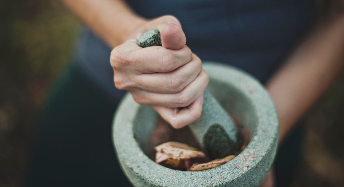 a hand grounds compounds with a pestle