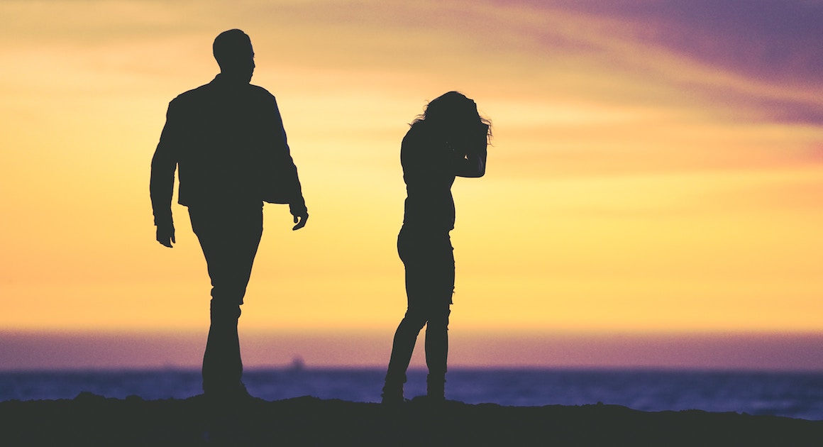 man walks toward a grieving woman