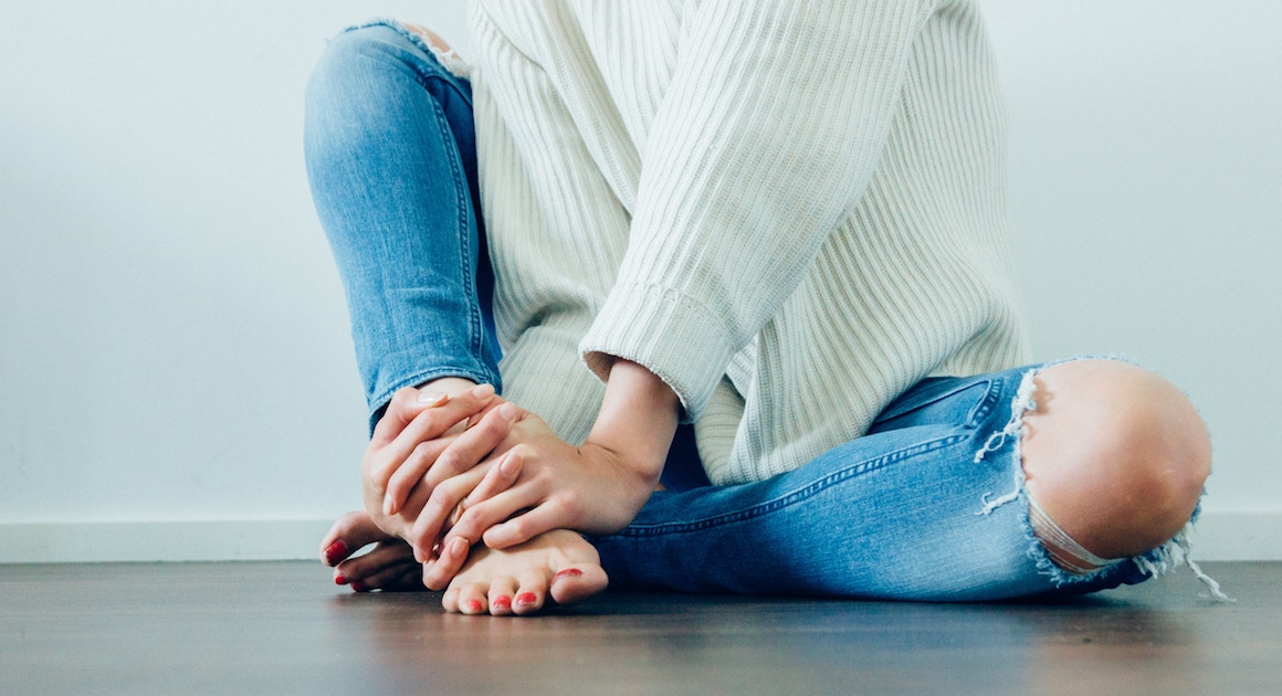 woman holding her foot in pain