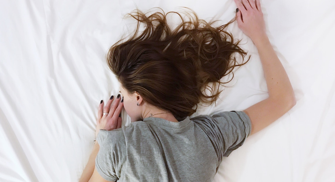 a woman sleeping with one arm over her head