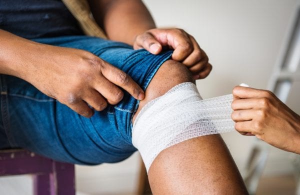 medic wrapping an injured knee