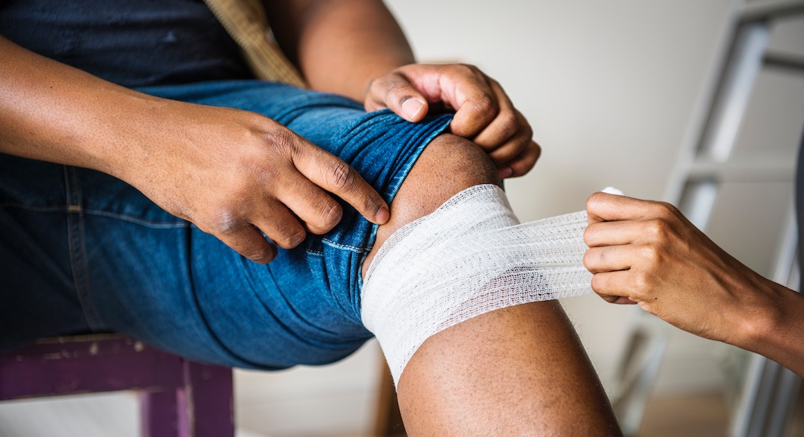 medic wrapping an injured knee