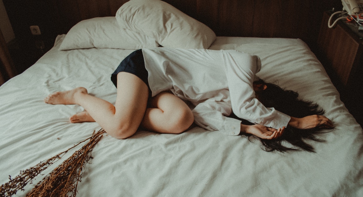 woman lying collapsed on a bed