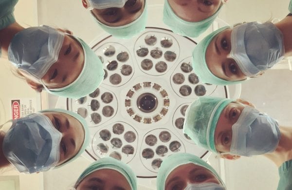 doctors in a circle looking down at a patient