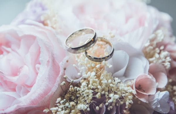 two wedding rings on a floral arrangement