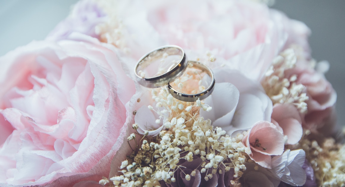 two wedding rings on a floral arrangement