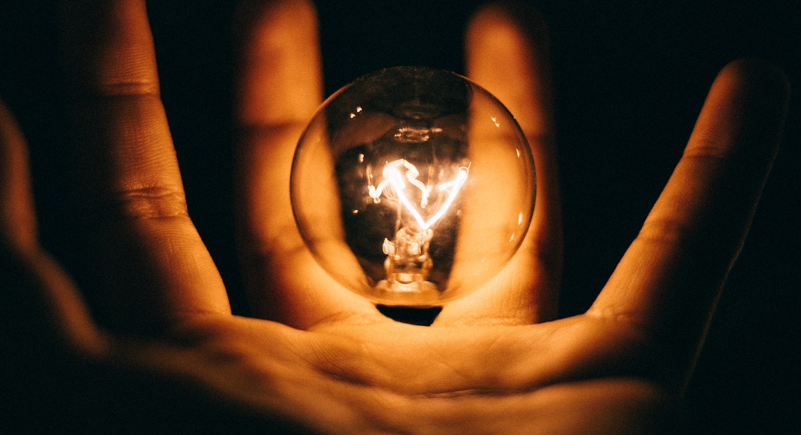 a light hovering over a palm