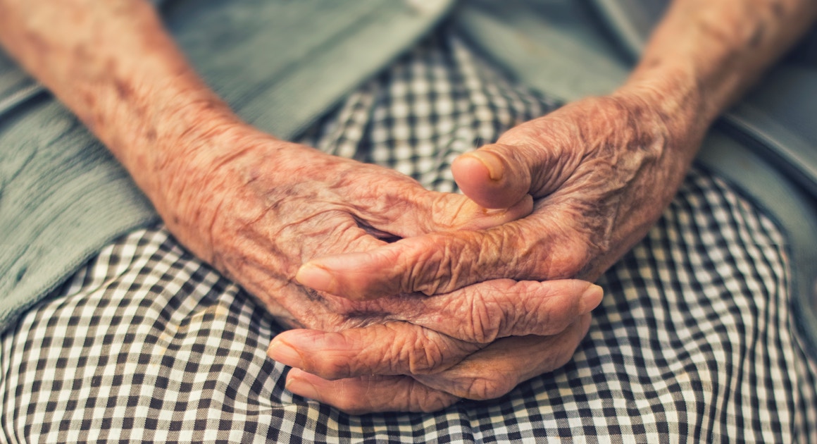 a woman with arthritis clasps her hands on her lap