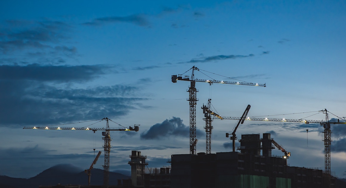 a series of cranes at a construction site