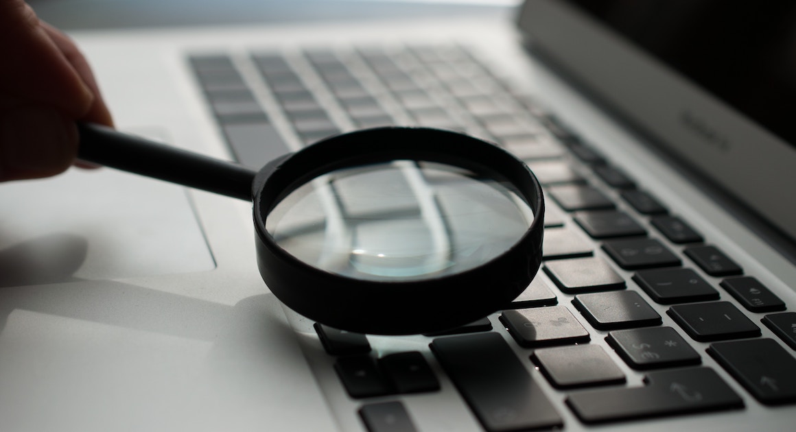 magnifying glass held over a laptop computer