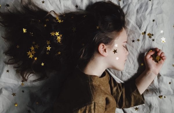 sleeping girl on a bed with stars in her hair
