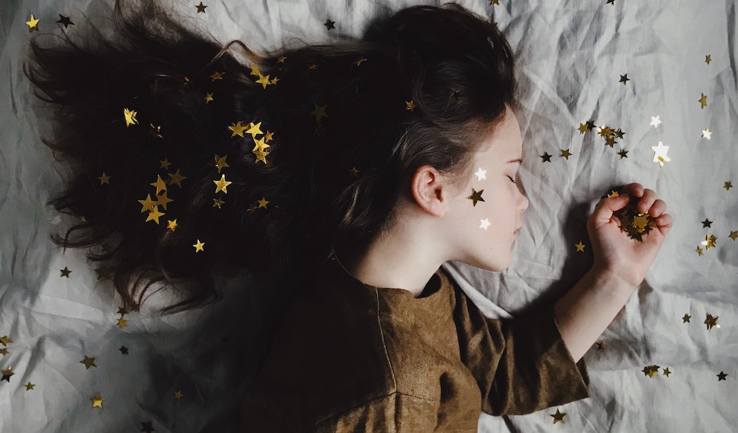sleeping girl on a bed with stars in her hair