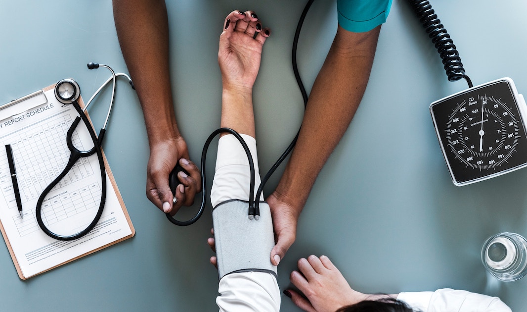 a nurse checks a patient's blood pressure