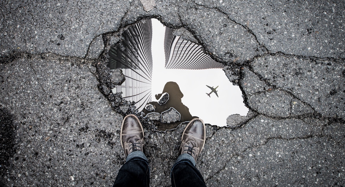 two feet look down at a crack in the street