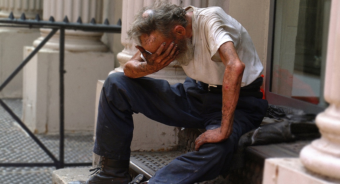 old man holding his head in his hands