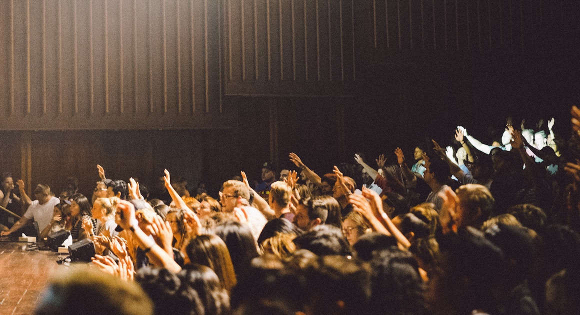 a classroom of people raising their hands